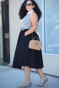 Tanesha Awasthi, also known as Girl With Curves, wearing a tie-waist crop top, black midi skirt, animal print lace-up flats and Chanel bag.