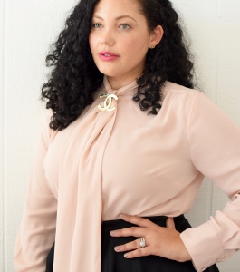 Tanesha Awasthi, also known as Girl With Curves, shares 1 of 3 ways to style a tie-neck blouse with a vintage Chanel brooch.