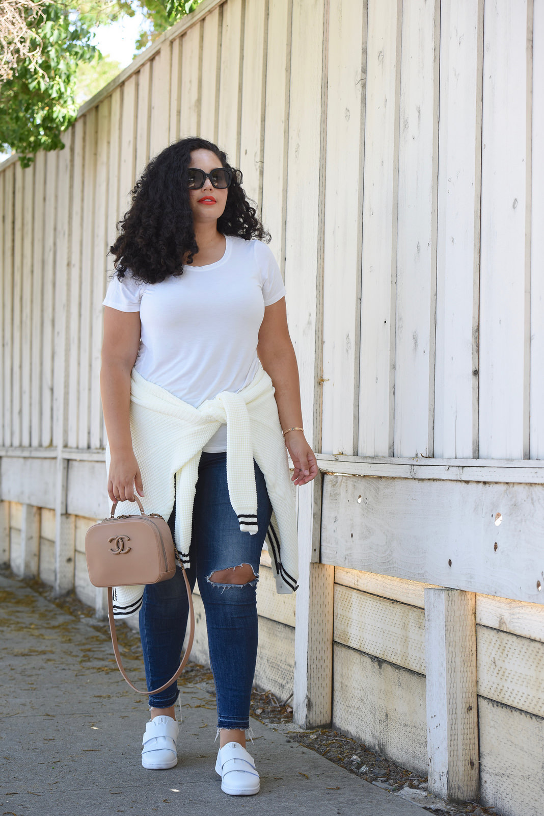 Tanesha Awasthi, also known as Girl With Curves, wearing a preppy cardigan, jeans, white sneakers and Chanel bag.