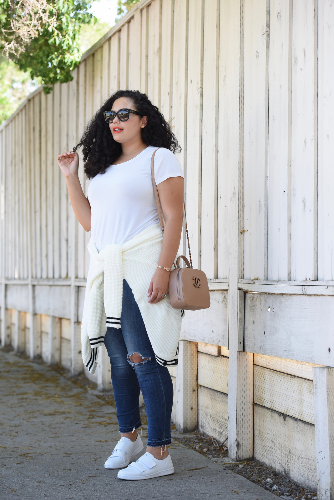 Tanesha Awasthi, also known as Girl With Curves, wearing a white tee, plus size skinny jeans, white sneakers and Chanel bag.