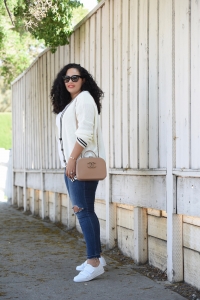 Tanesha Awasthi, also known as Girl With Curves, wearing a white tee, preppy cardigan, plus size skinny jeans, white sneakers and Chanel bag.