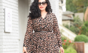 Tanesha Awasthi, also known as Girl with Curves, wearing a long sleeve plus size floral midi dress.