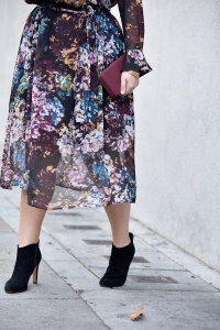 Girl With Curves blogger Tanesha Awasthi wears a long sleeve floral print dress midi dress and booties