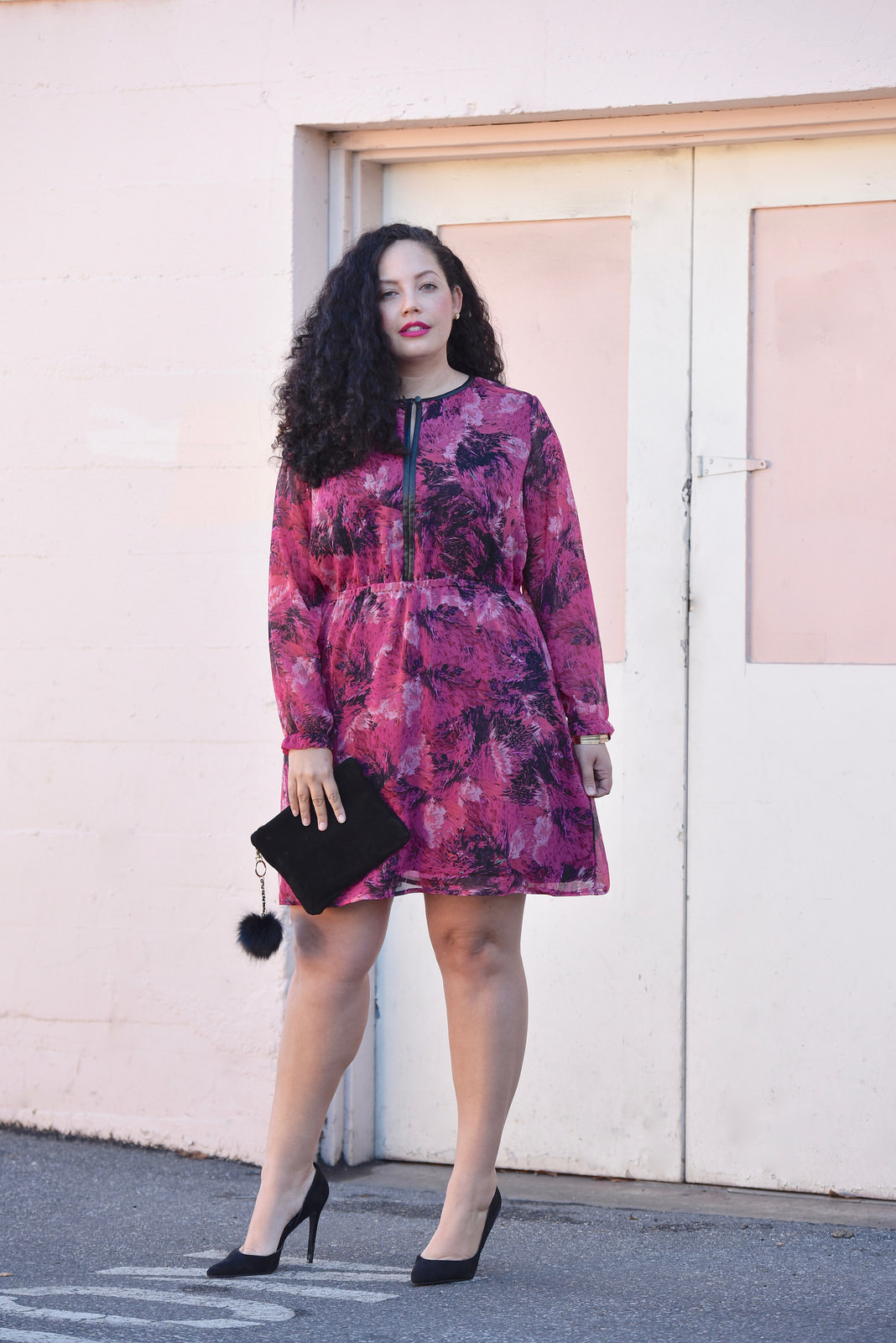 Girl With Curves blogger Tanesha Awasthi wears a long sleeve floral print mini dress.