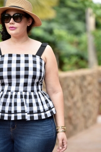Girl With Curves blogger Tanesha Awasthi wears a gingham peplum and boater hat in Hawaii.