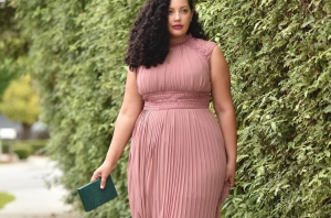 Girl With Curves blogger Tanesha Awasthi wears a pink plus size maxi dress with lace details.