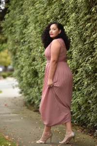 Girl With Curves blogger Tanesha Awasthi wears a lace detail plus size maxi dress and emerald green accessories.