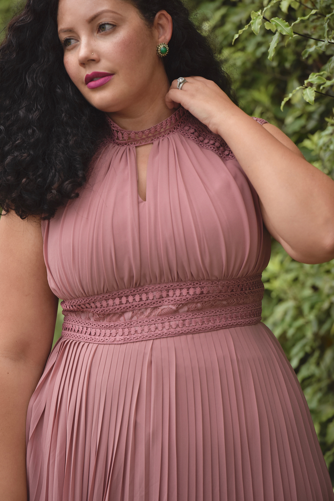Girl With Curves blogger Tanesha Awasthi wears a lace detail plus size maxi dress and emerald accessories.