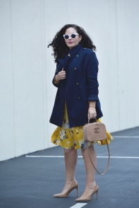 Girl With Curves blogger Tanesha Awasthi, in post Winter Brights, is wearing an Old Navy yellow floral Dress and navy peacoat.