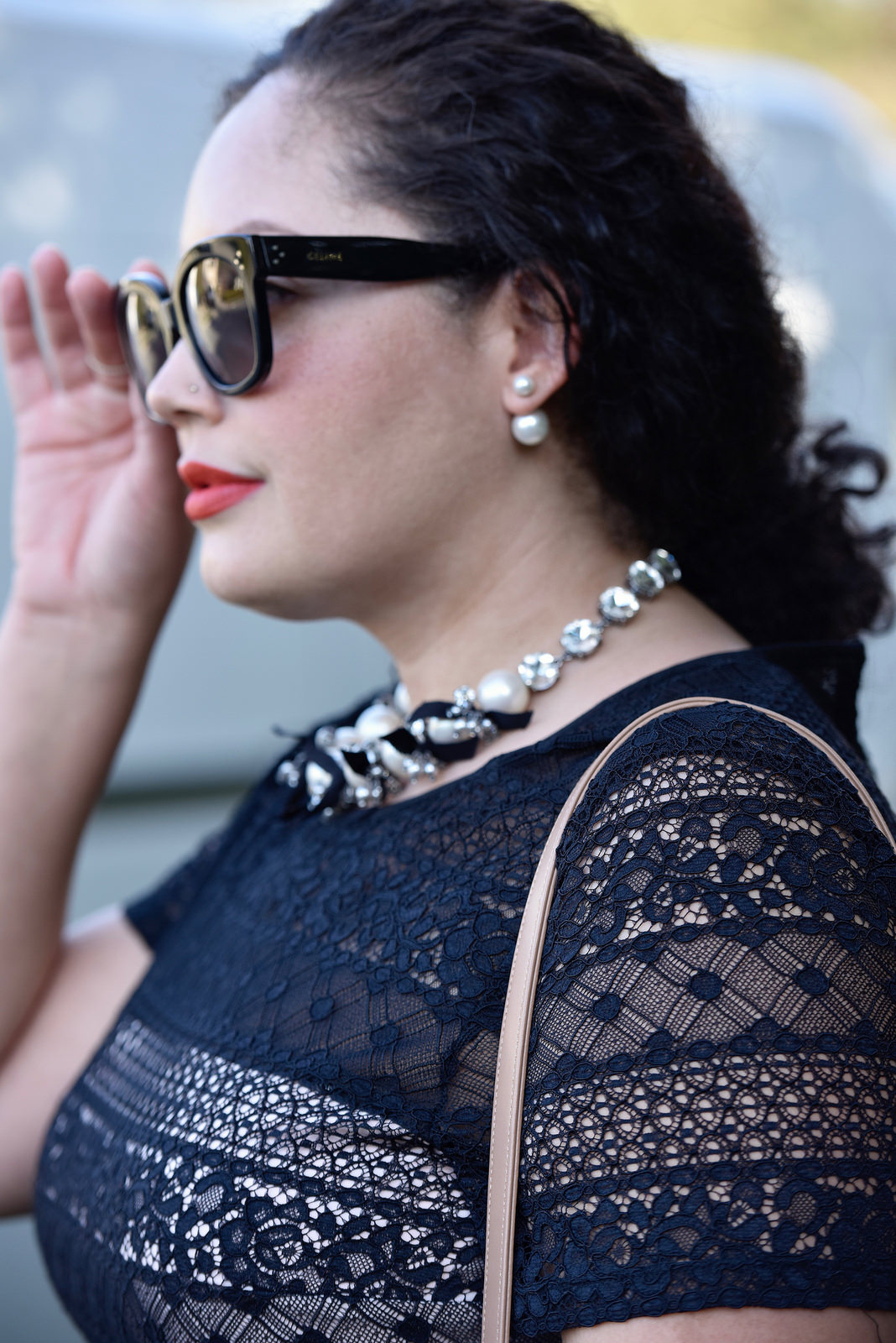 Girl With Curves wearing a pearl necklace from Ann Taylor, Audrey Sunglasses from Celine and Lace Dress from Maggy London at Nordstrom.